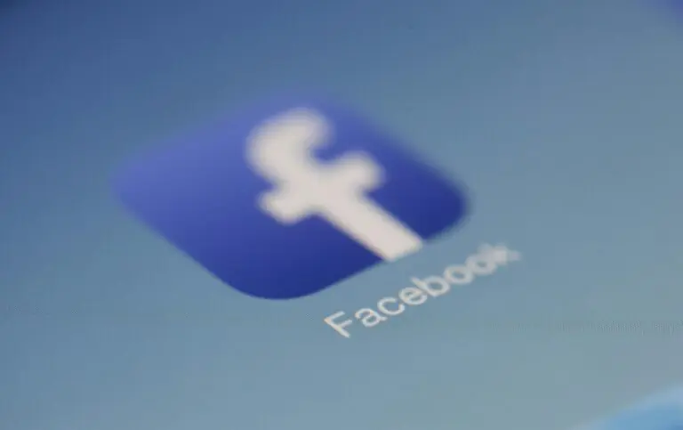 Facebook app logo on digital screen with blurred background closeup.