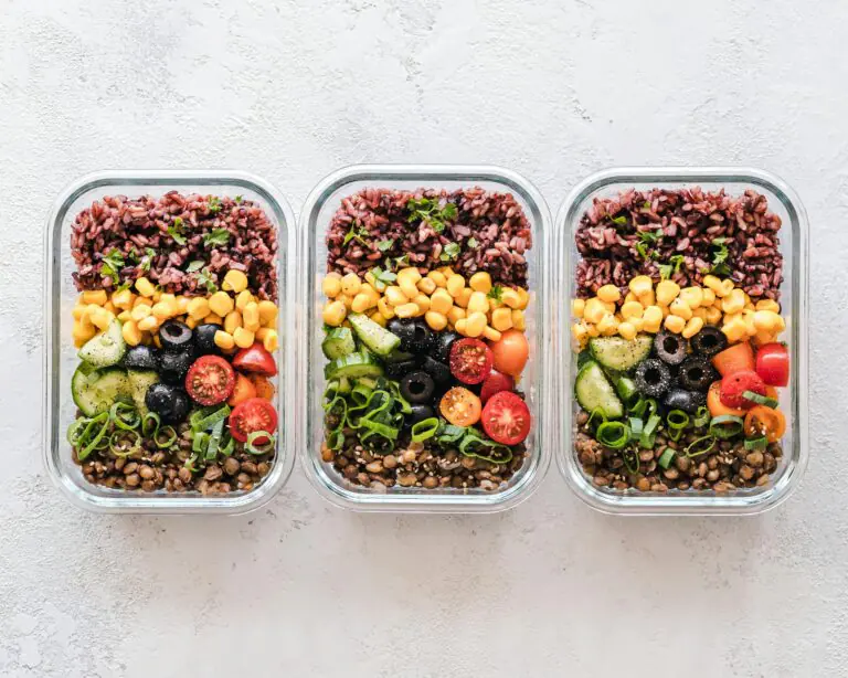 Colorful healthy meal prep with corn olives tomatoes and lentils in glass containers