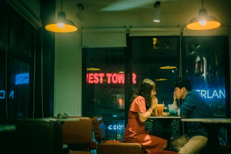 Couple enjoys drinks and quiet evening inside cozy cafe.