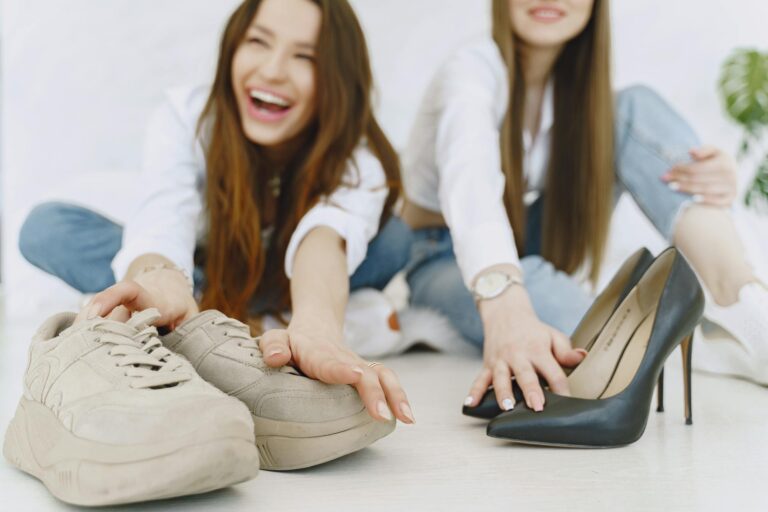 Young woman choosing between elegant black heels and comfortable trendy sneakers.