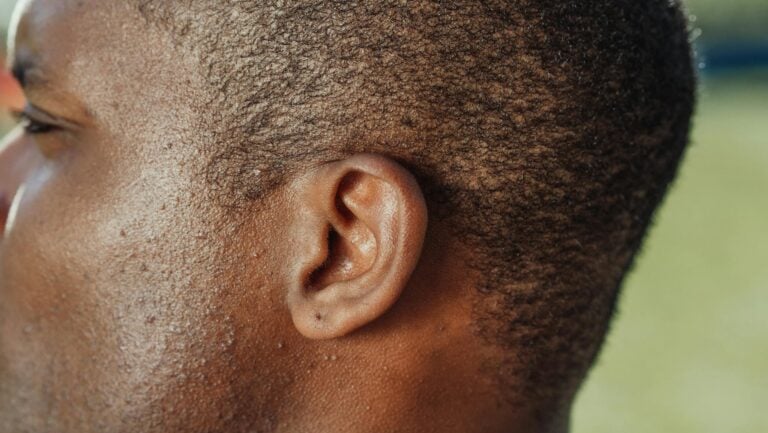 Close-up detailed texture of person's ear, skin and hair in detail.