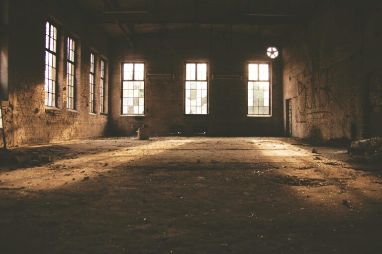Dilapidated factory interior with sunlight streaming through windows