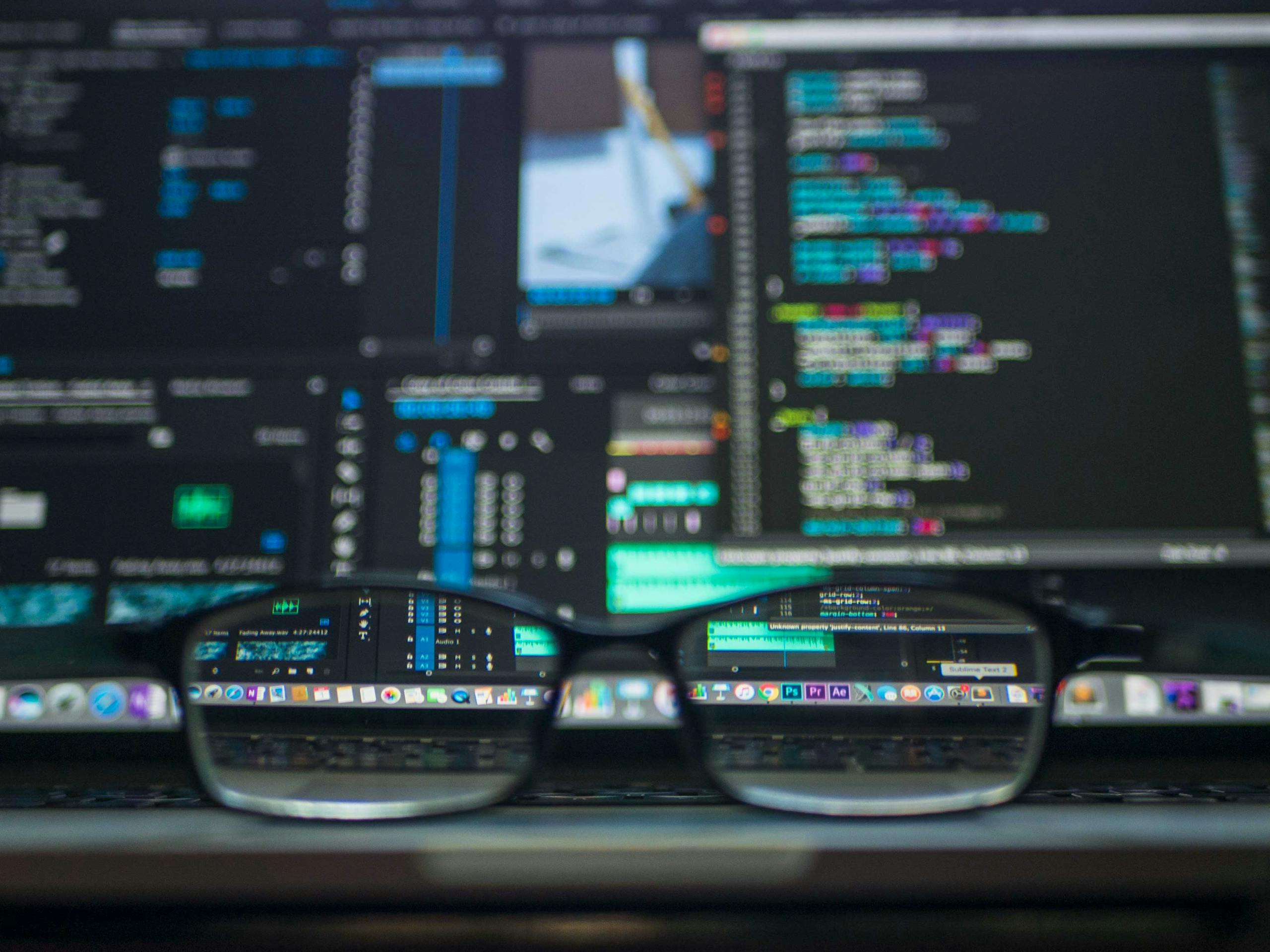 Eyeglasses reflecting computer code on monitor screen