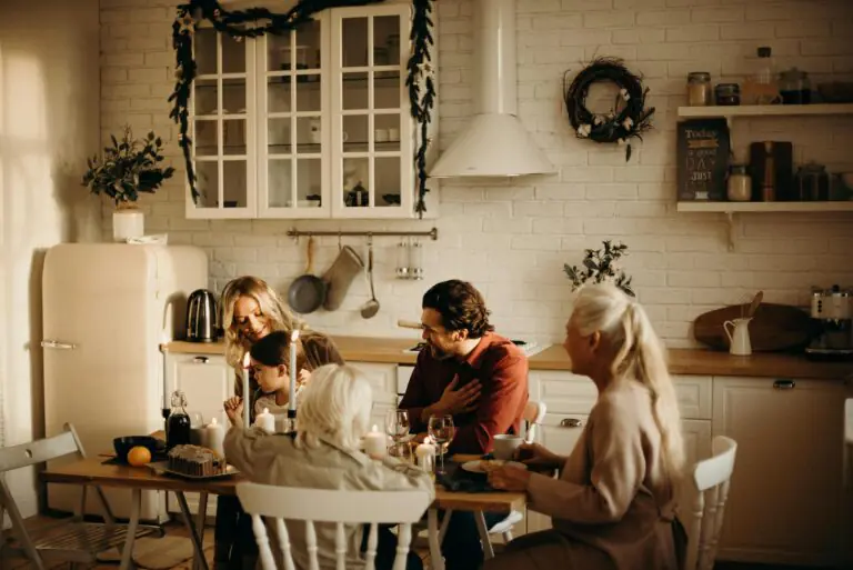 Family enjoying holiday meal in cozy warmly lit dining room with candles