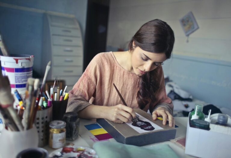 Female artist deeply engaged in painting at creative studio workspace