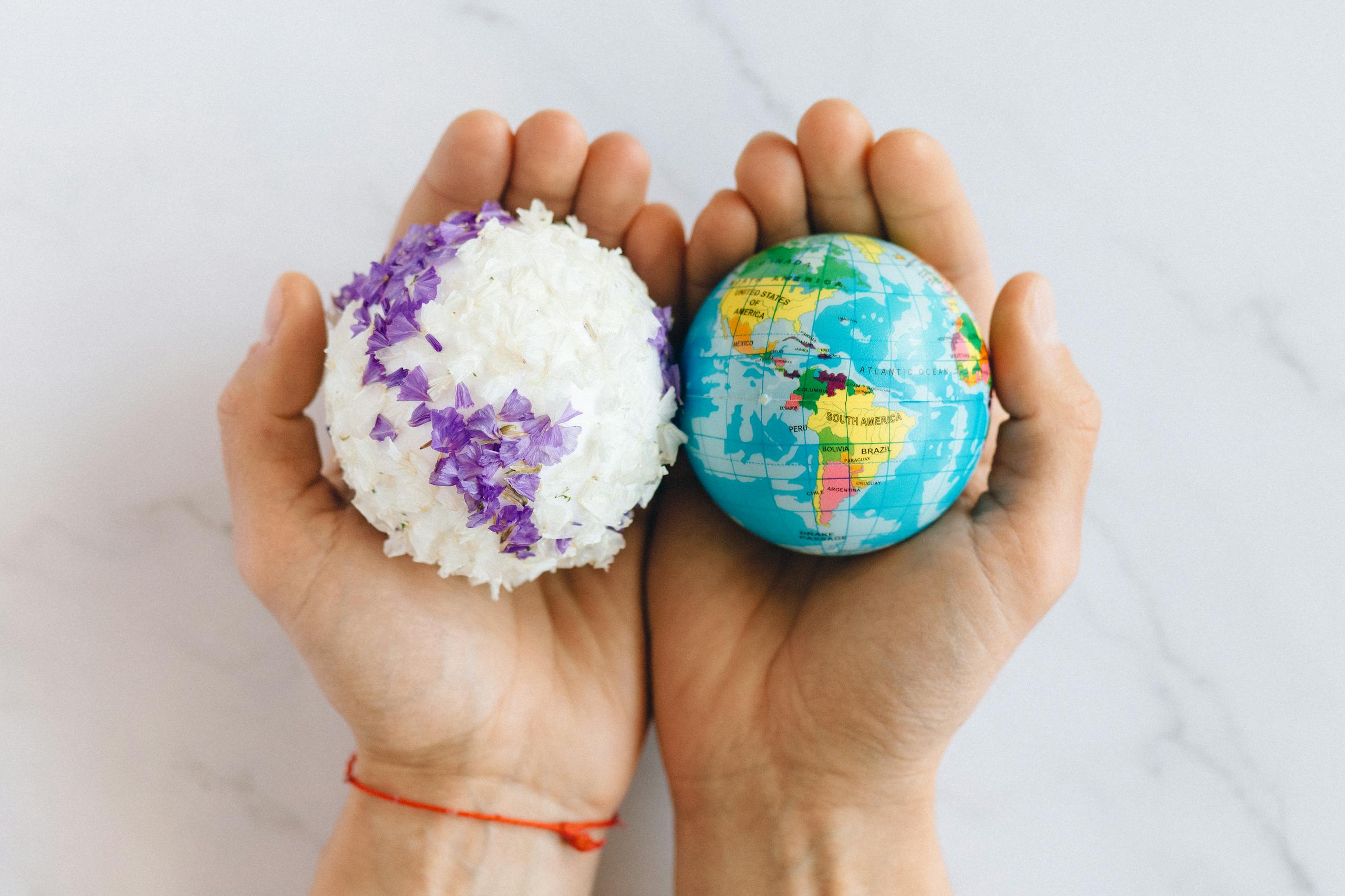 Hands holding globe and floral sphere symbolizing care and environmental consciousness.