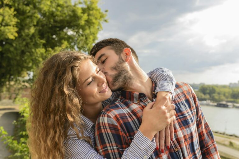 Happy couple sharing loving embrace outdoors with scenic background