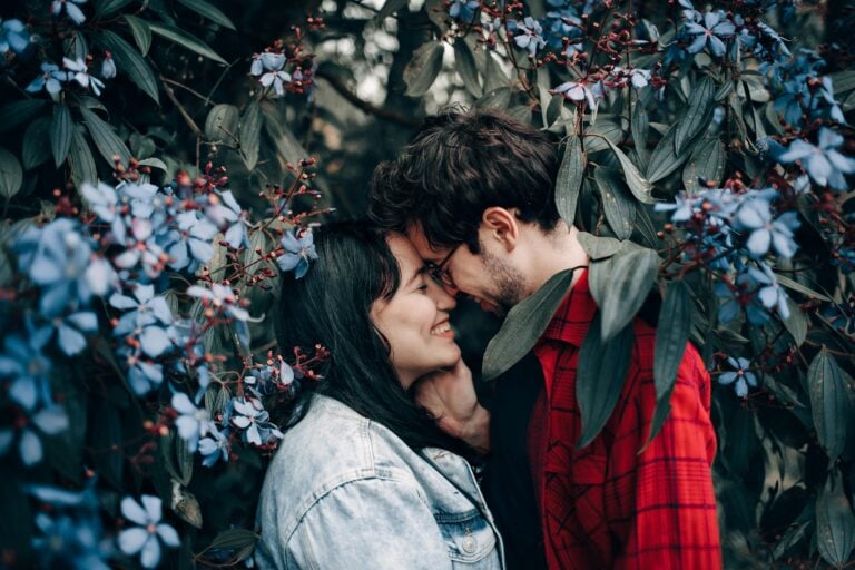 Couple sharing romantic moment surrounded by beautiful blue flowers