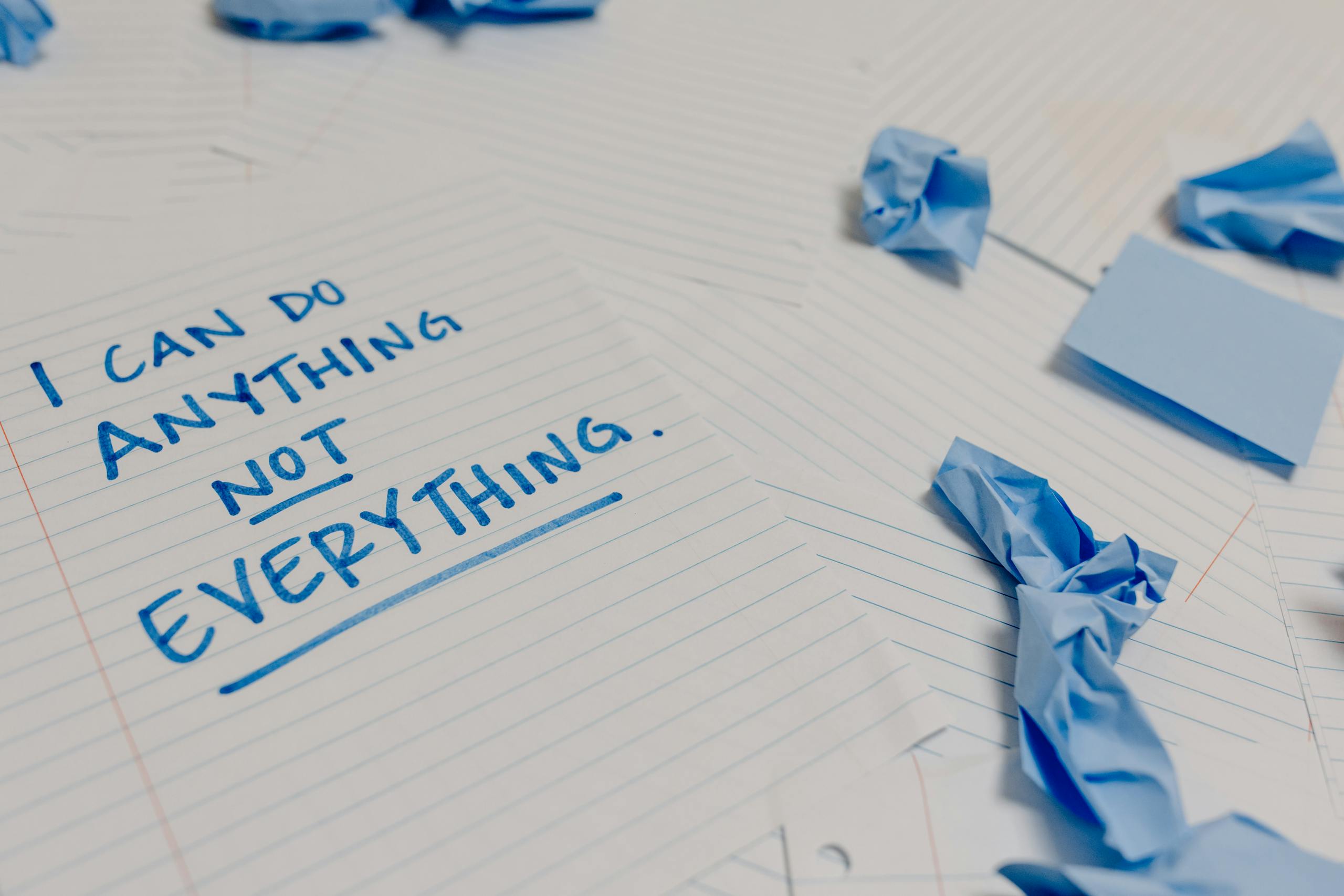 Motivational message on page surrounded by crumpled papers and blue sticky notes