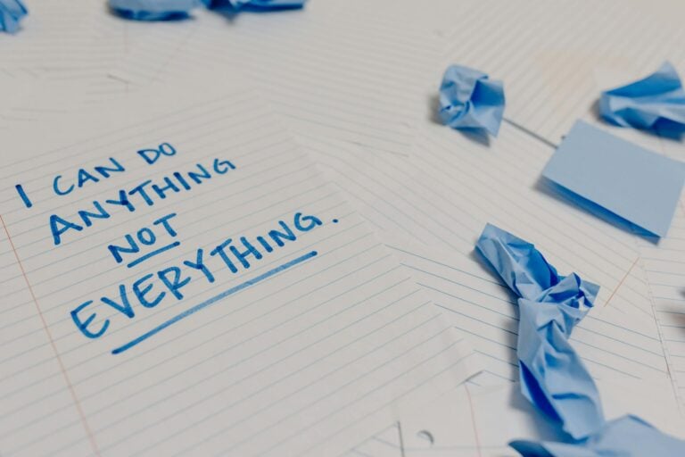 Motivational message on page surrounded by crumpled papers and blue sticky notes