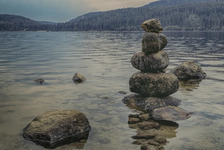 Peaceful lake scene with rock balancing showcasing scenic nature landscape
