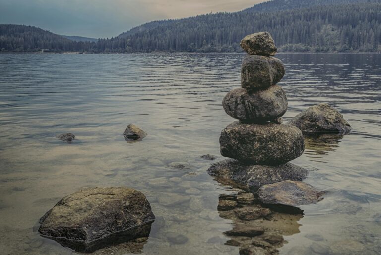 Peaceful lake scene with rock balancing showcasing scenic nature landscape