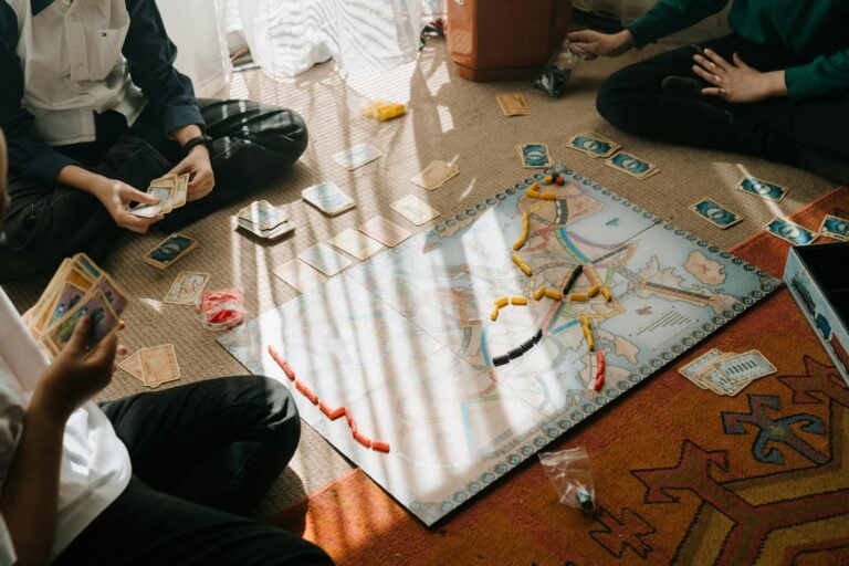 Small group of friends playing strategic board games at table