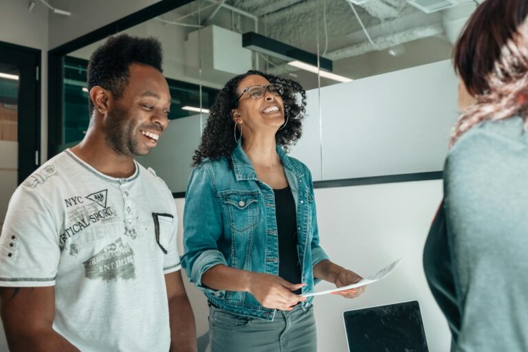 Smiling couple discussing with an advisor in a modern professional office setting.