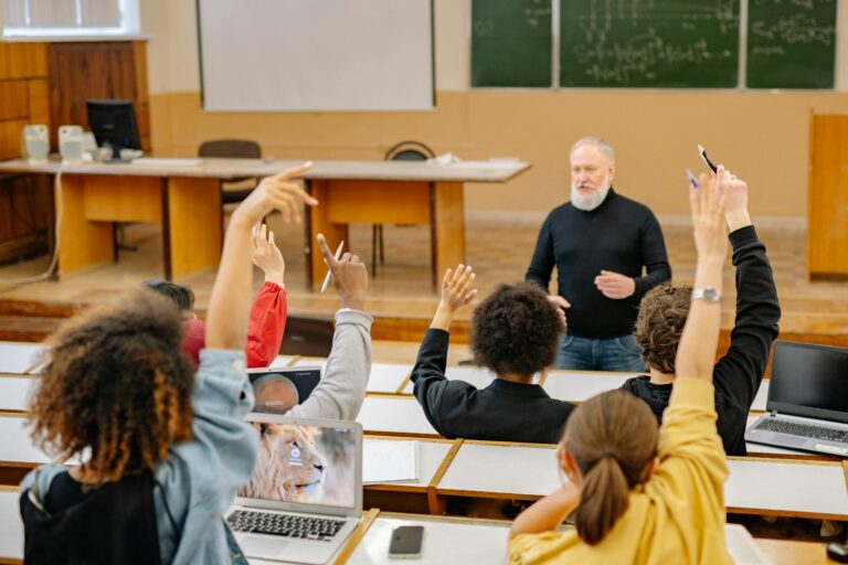 Students actively participate in university lecture raising hands and discussing topics.