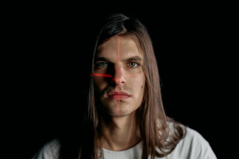 Studio portrait of man with long hair featuring facial recognition laser grid