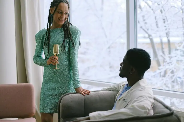 Stylish couple celebrating indoors with drinks by frosty window.