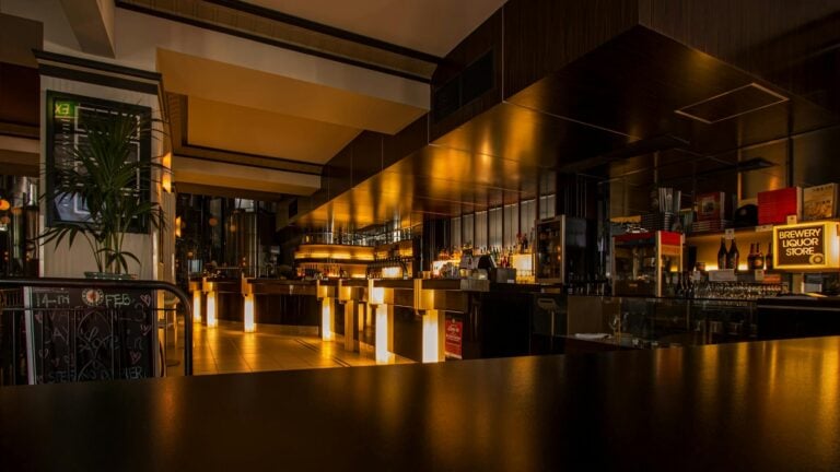 Stylish modern restaurant interior with warm lighting, elegant design, and luxurious nighttime ambiance.