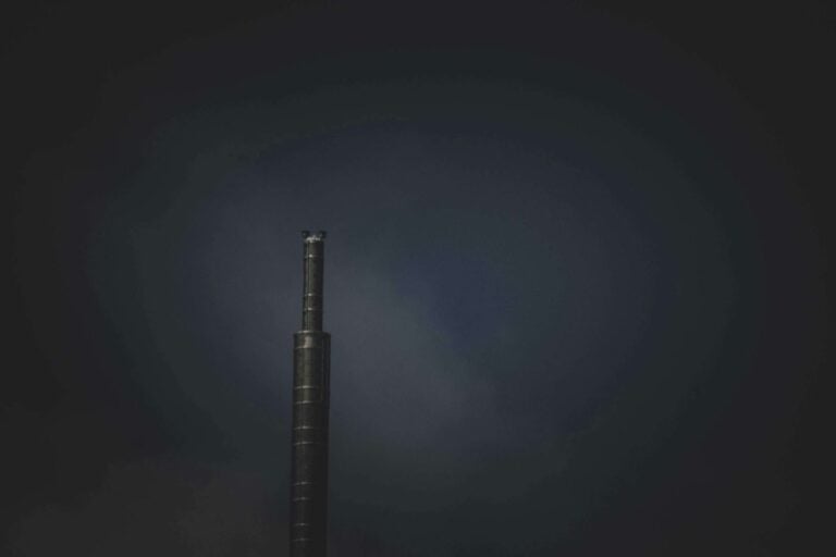 Solitary dark tower standing alone against moody twilight sky