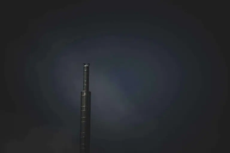 Solitary dark tower standing alone against moody twilight sky