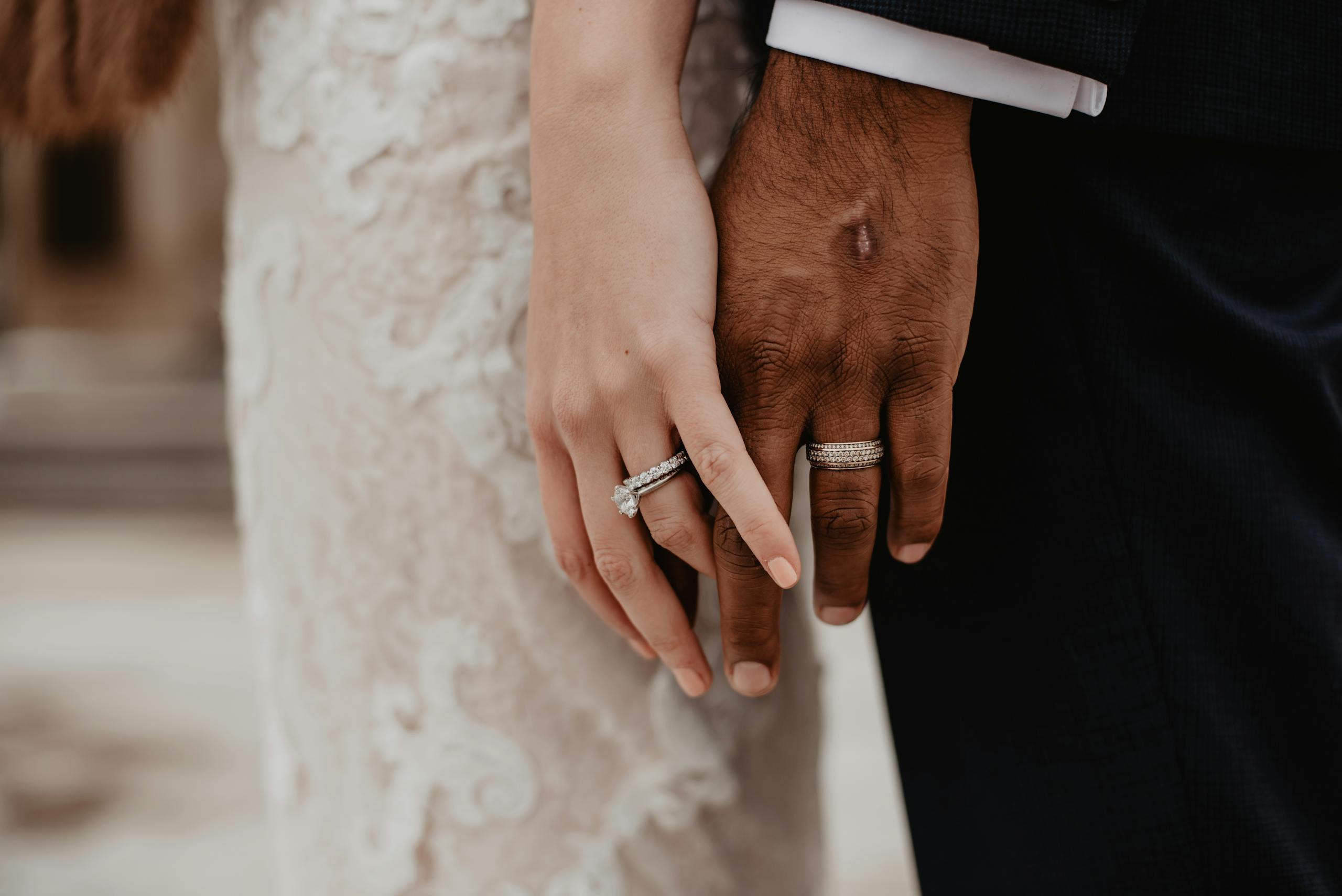 Two clasped hands showing wedding rings symbolizing unity and committed love