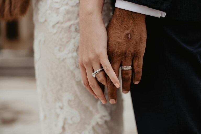 Two clasped hands showing wedding rings symbolizing unity and committed love