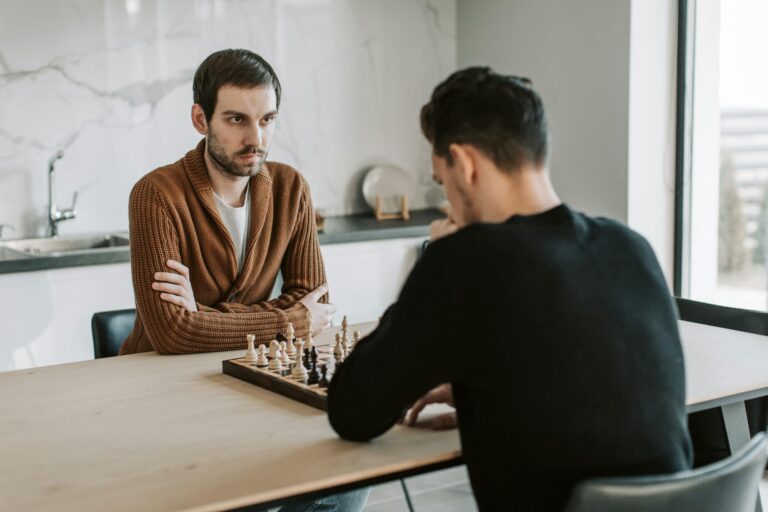 Two people engaged in deep conversation over chess representing INTJ friendship