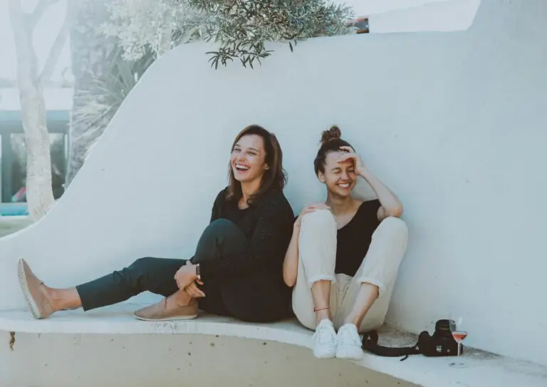 Two women laughing together outdoors enjoying friendship and leisure time