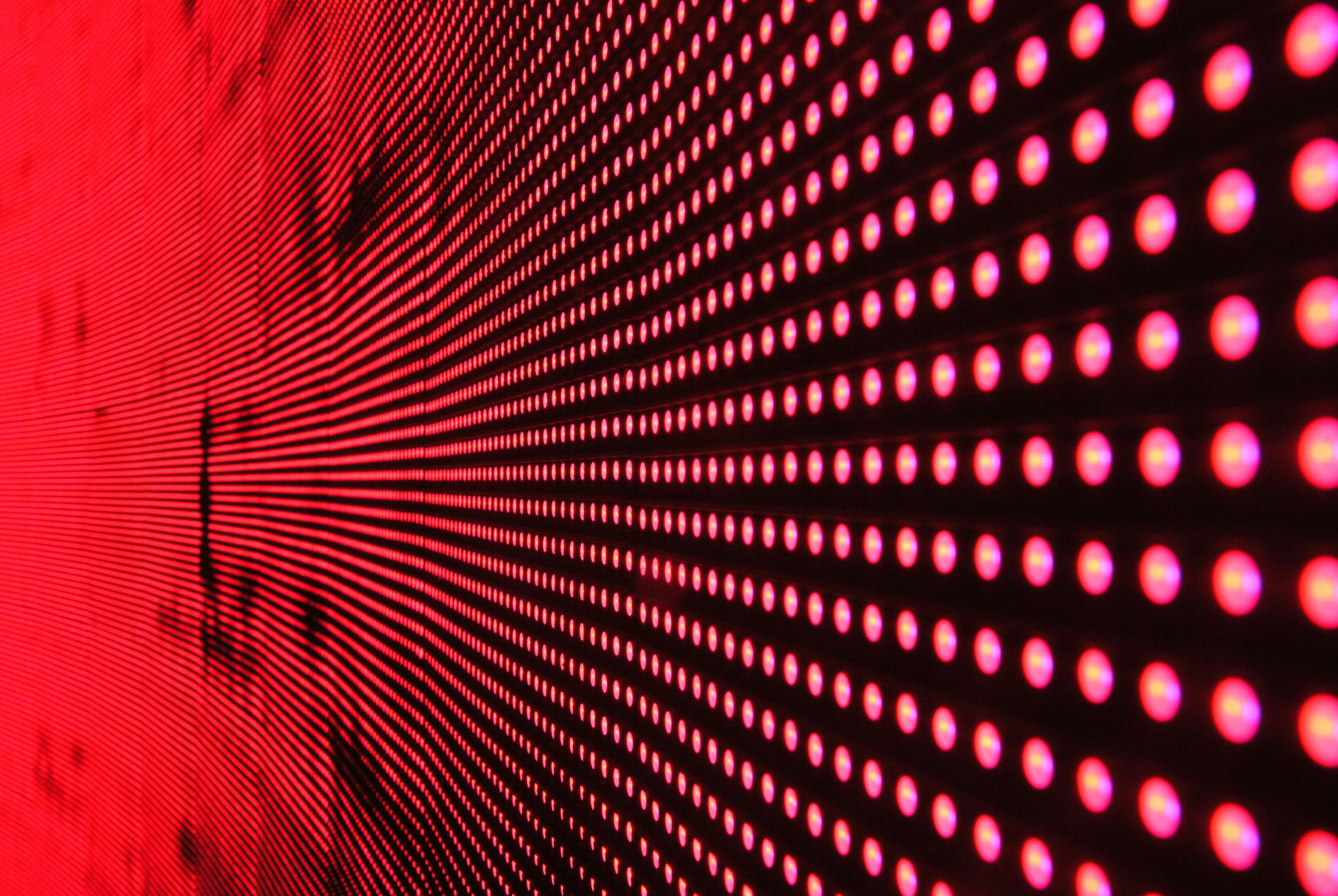Vibrant abstract pattern of illuminated red LED lights in dynamic design.
