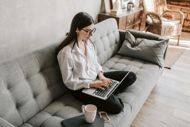 Woman in cozy home environment working on laptop balancing productivity and relaxation comfort