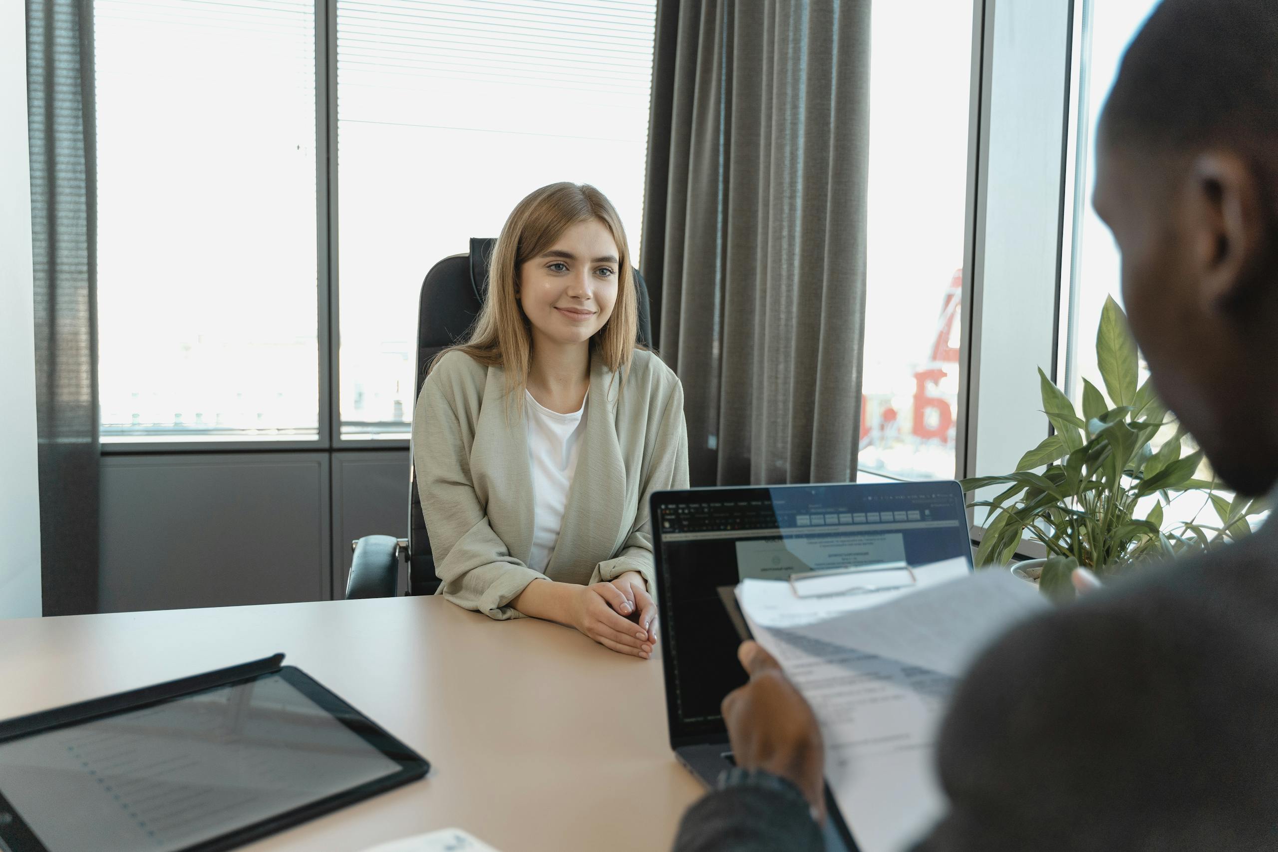 Young woman sitting confidently in modern office during job interview setting