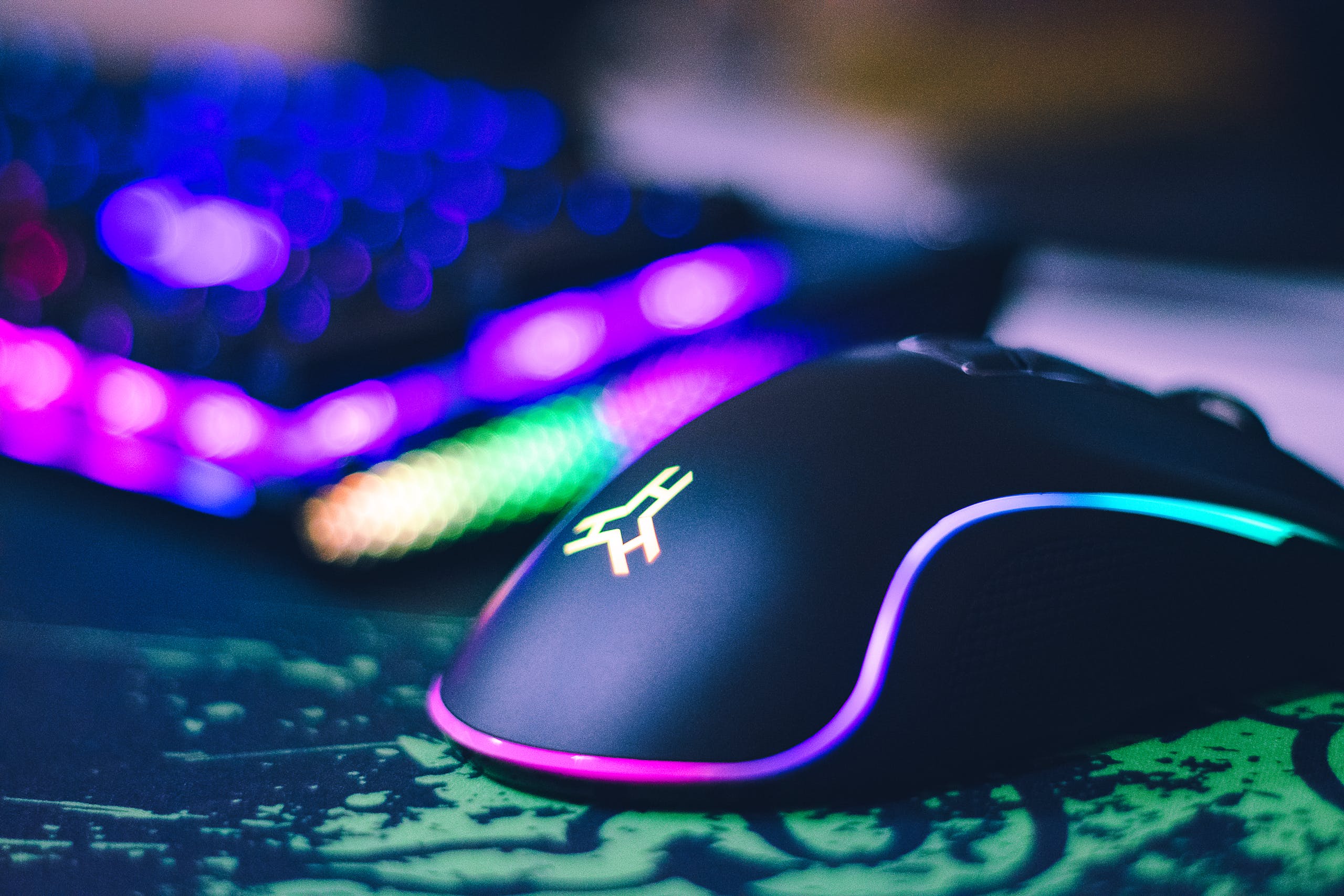 Close-up of colorful gaming mouse and illuminated RGB keyboard