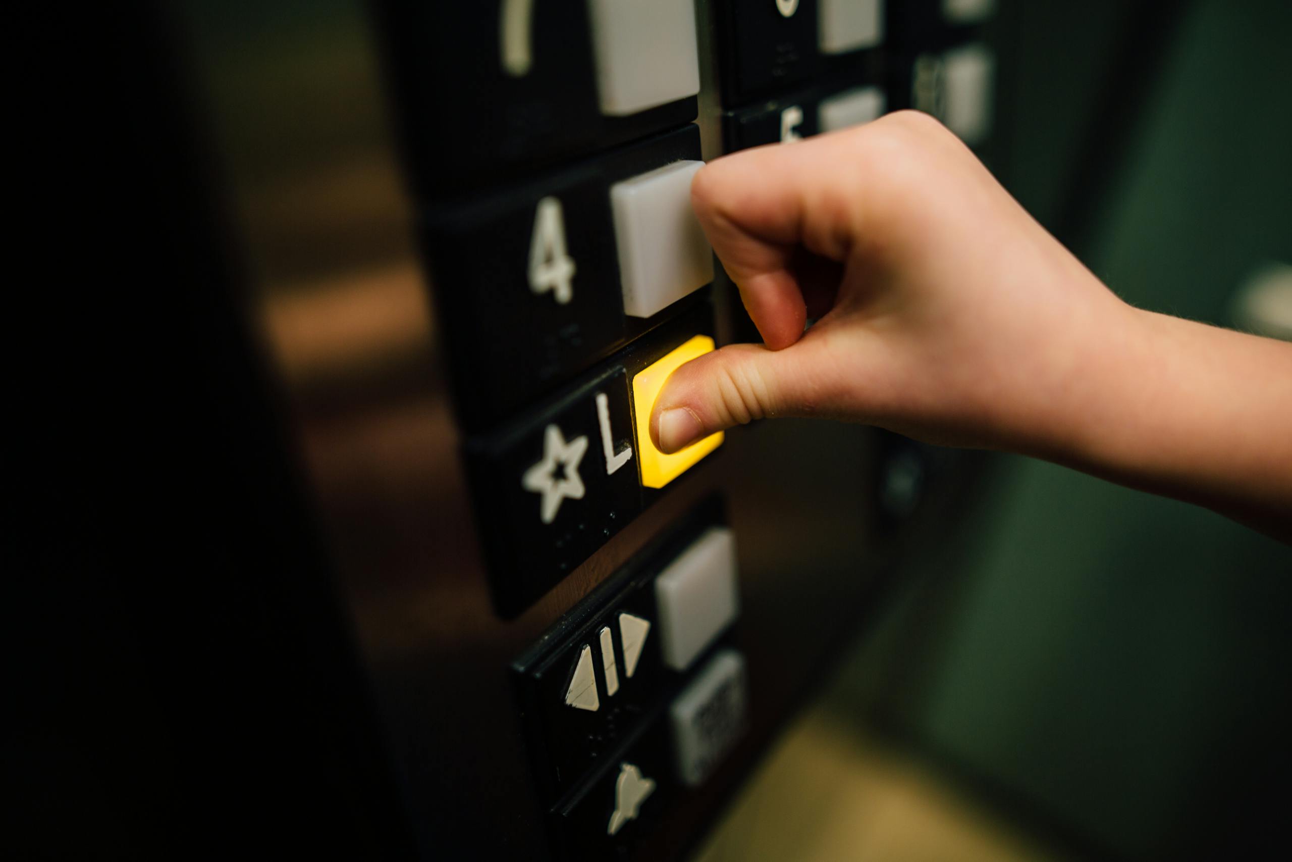 Close up shot of hand pushing elevator button indoors
