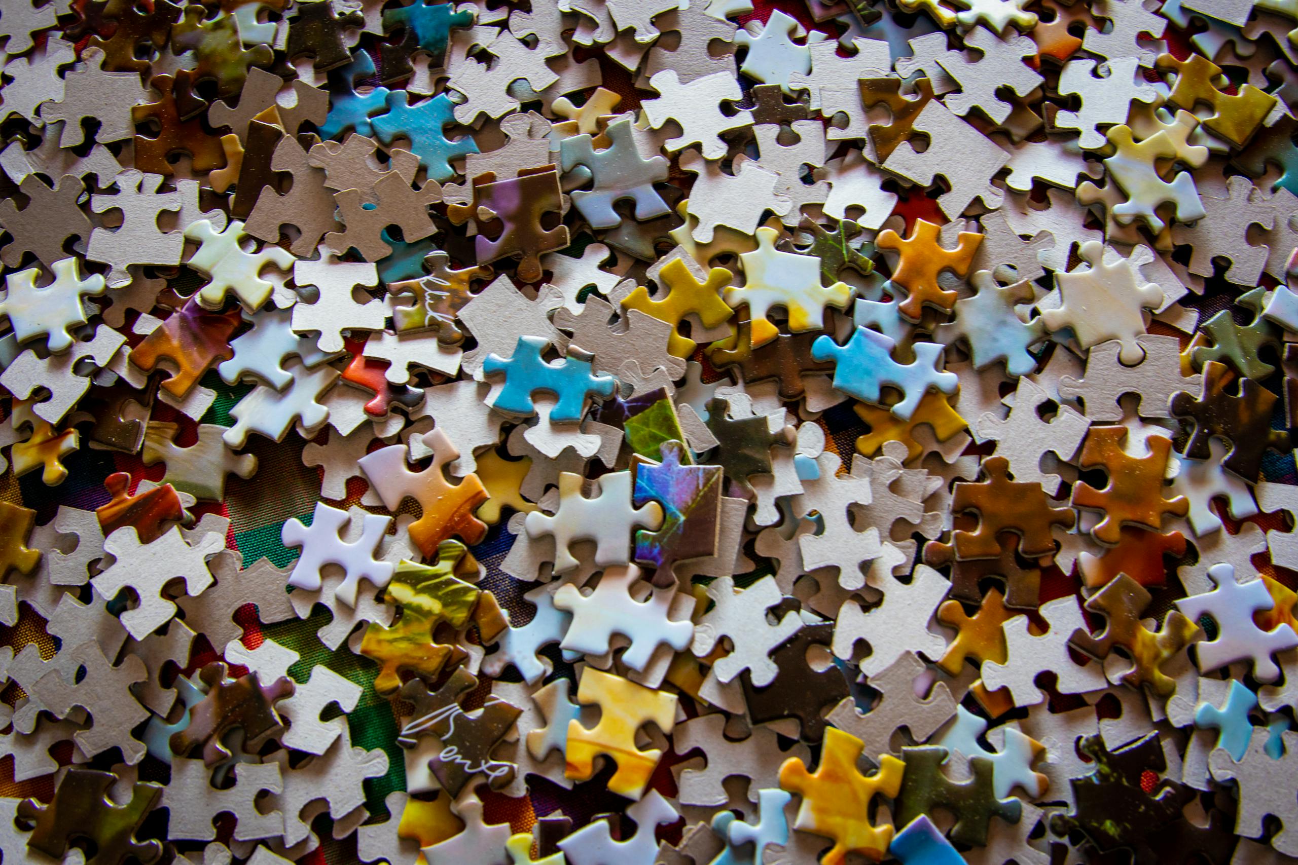 Close-up view of colorful jigsaw puzzle pieces scattered across a flat surface