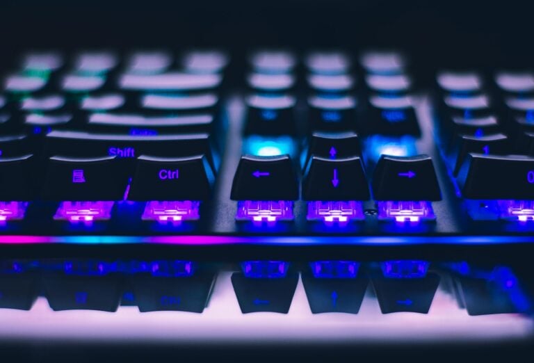 Close-up of illuminated mechanical keyboard with blue purple lights