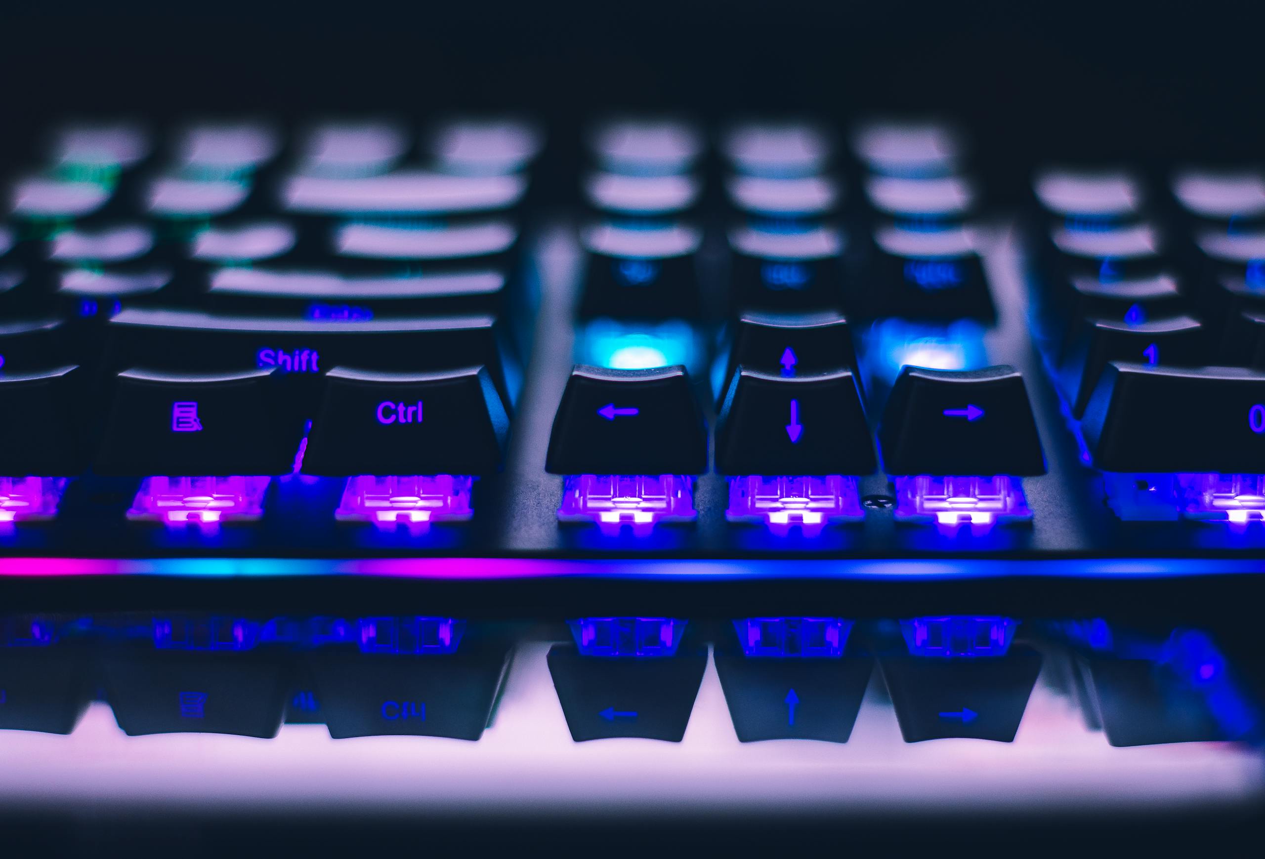 Close-up of illuminated mechanical keyboard with blue purple lights