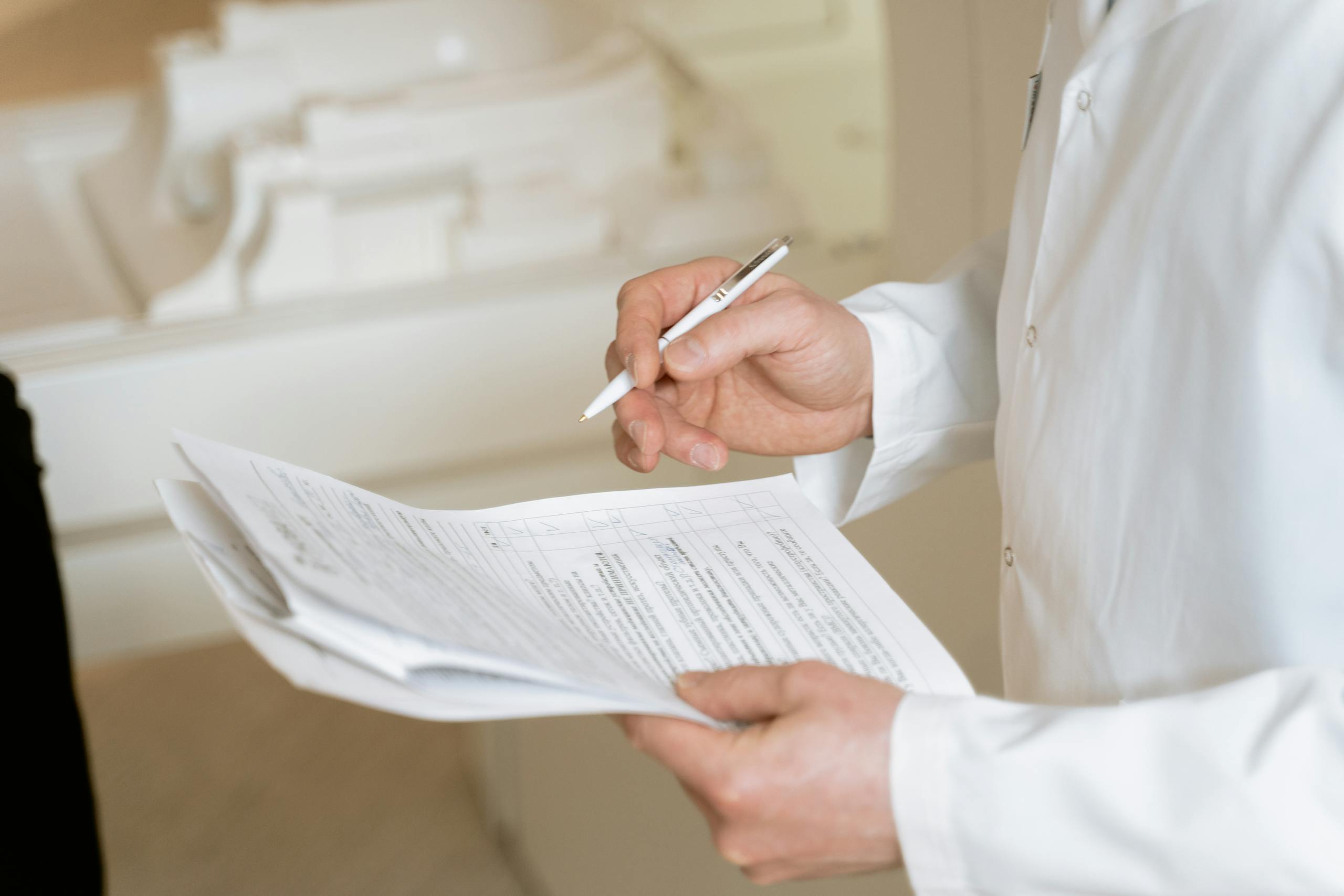 Doctor holding and reviewing medical documents with focused professional examination