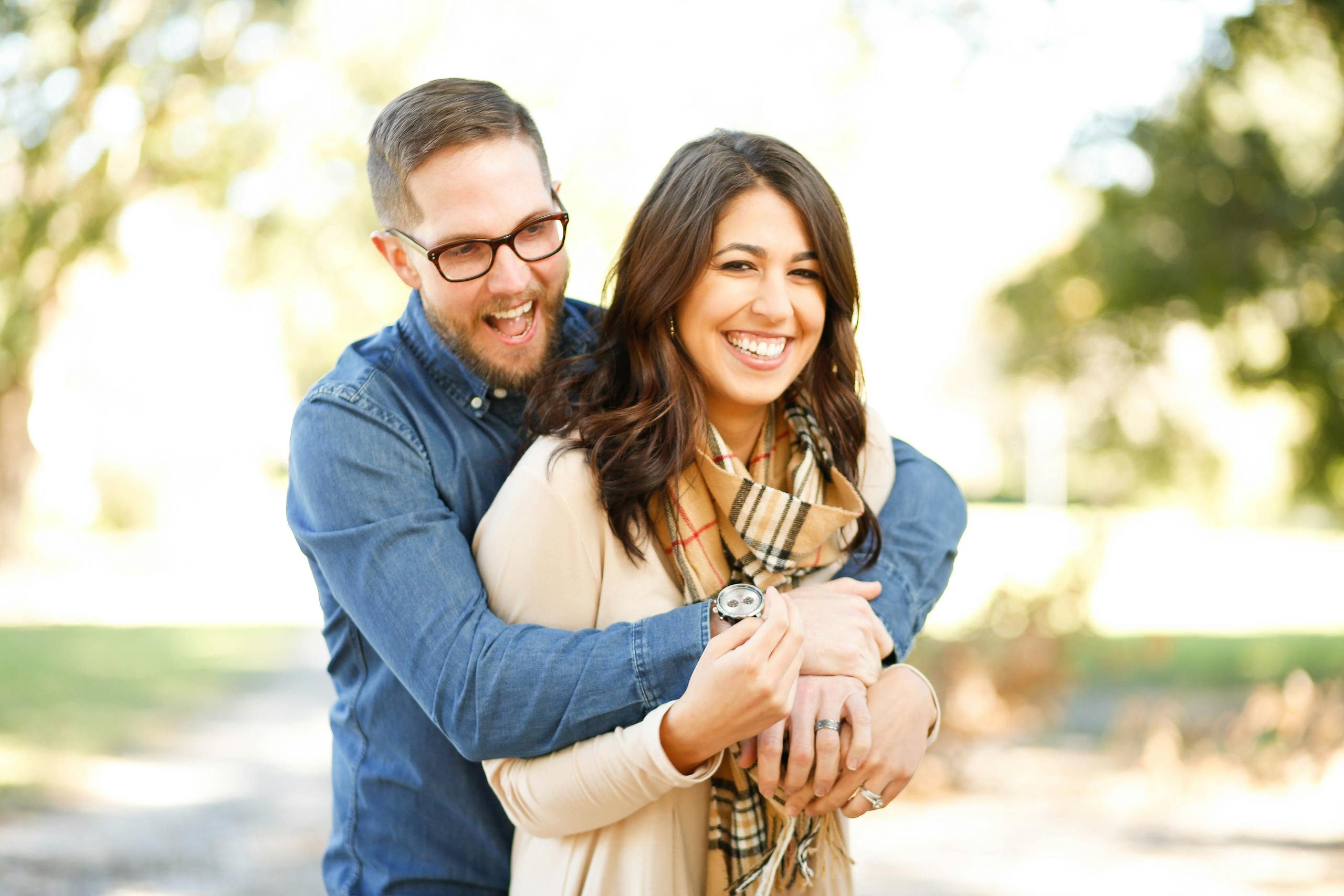 Happy couple enjoying outdoor engagement photoshoot with laughter and love