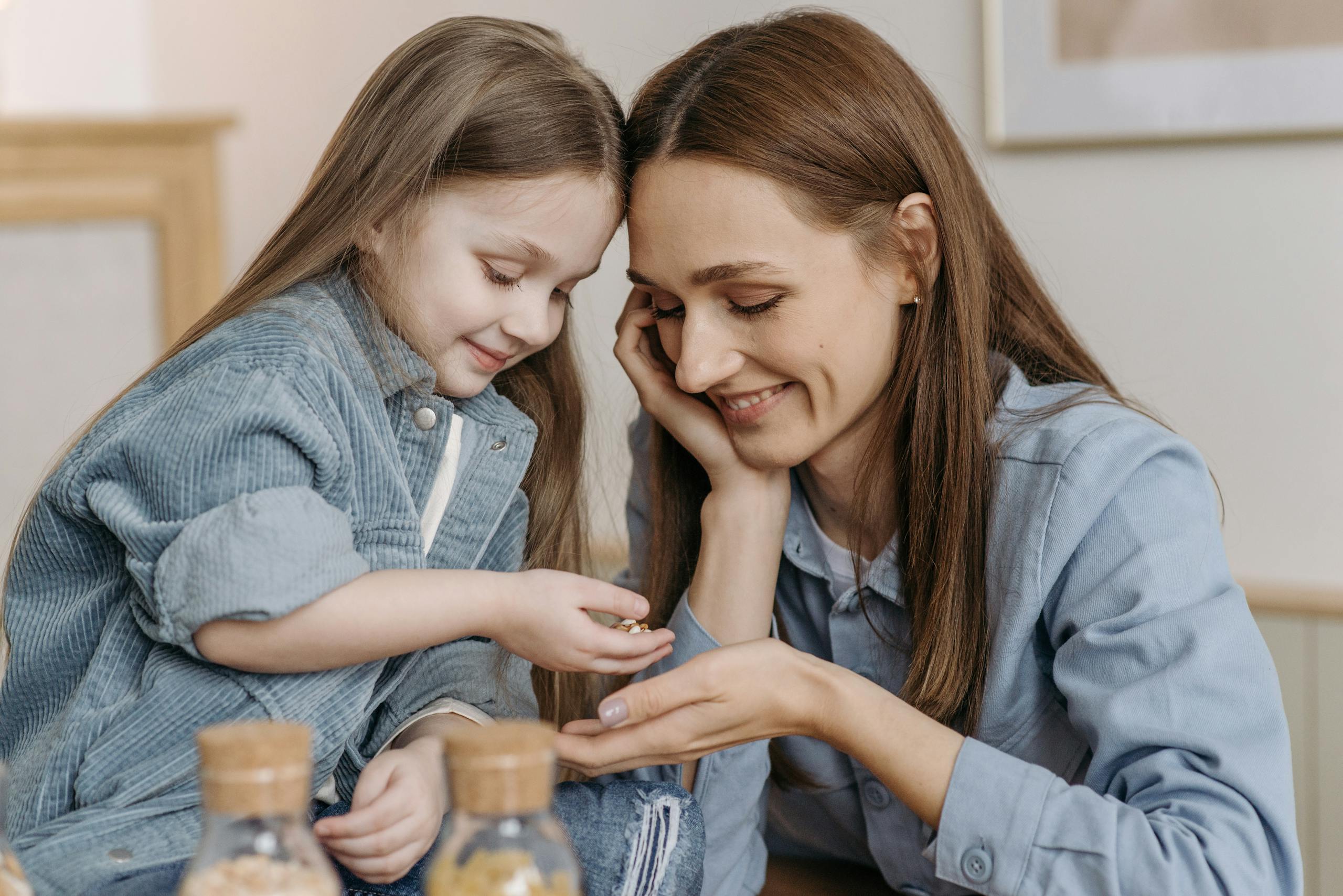 Touching moment between mother and daughter sharing smiles indoors