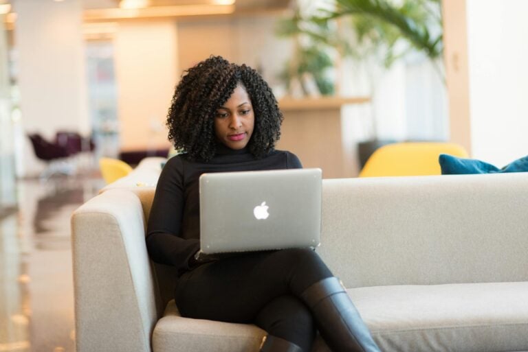 African american woman working remotely on laptop in modern setting