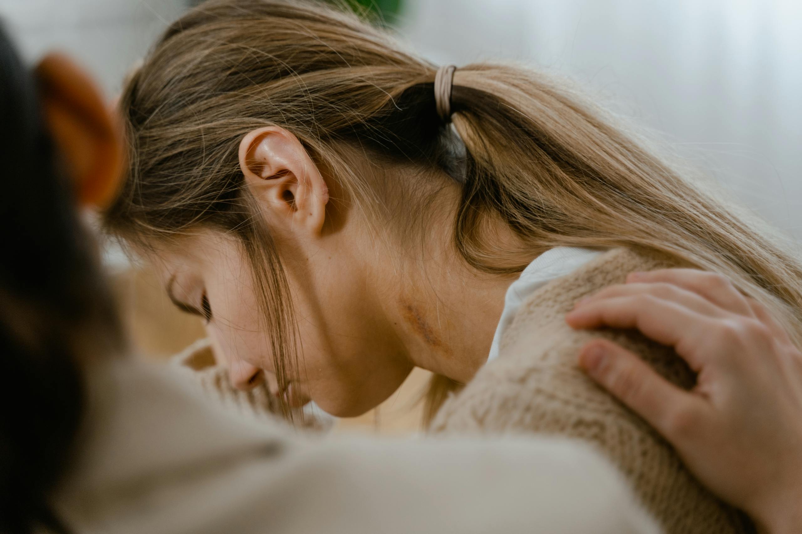 Comforting hand gesture on woman's shoulder showing emotional support.