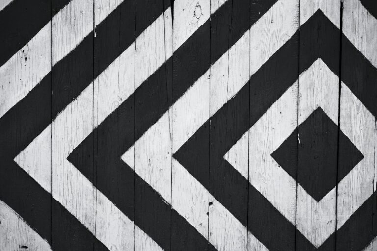 Black and white geometric pattern on wooden planks creating modern textured design backdrop