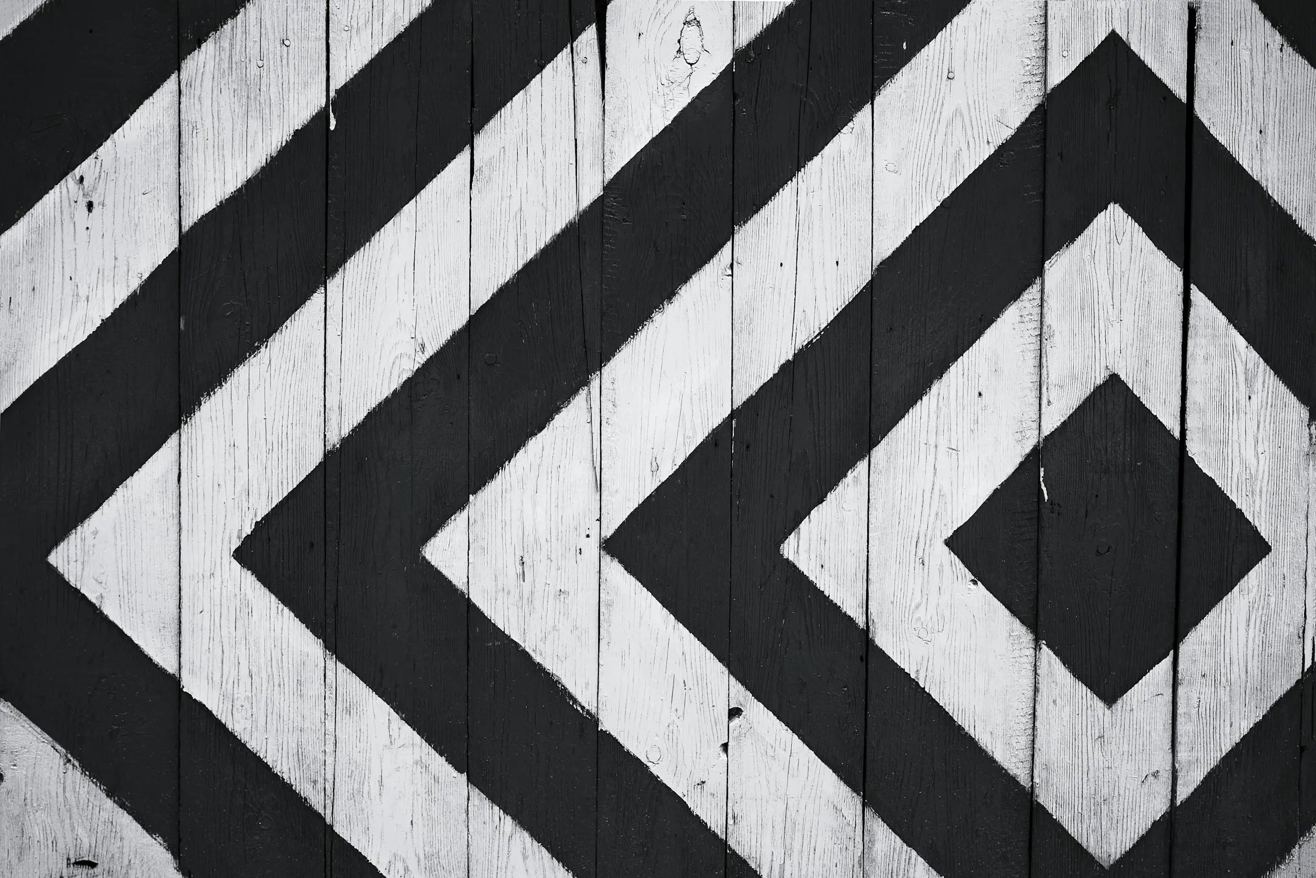 Black and white geometric pattern on wooden planks creating modern textured design backdrop