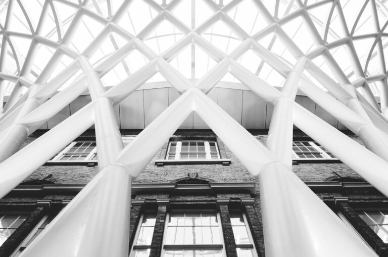 Black and white photo of intricate modern roof structure at Kings Cross Station London.