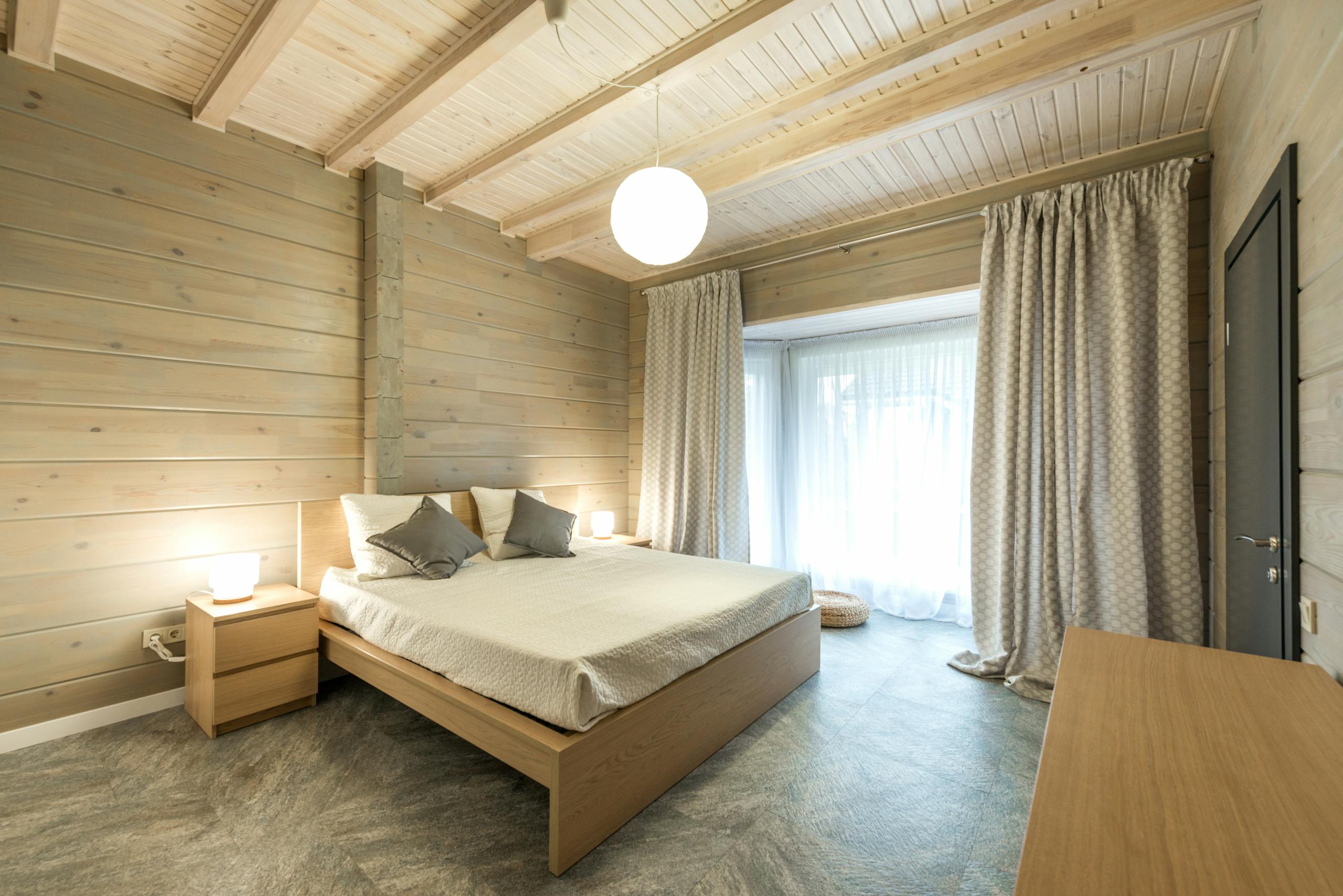 Bright spacious modern bedroom with wooden decor and neutral tones.