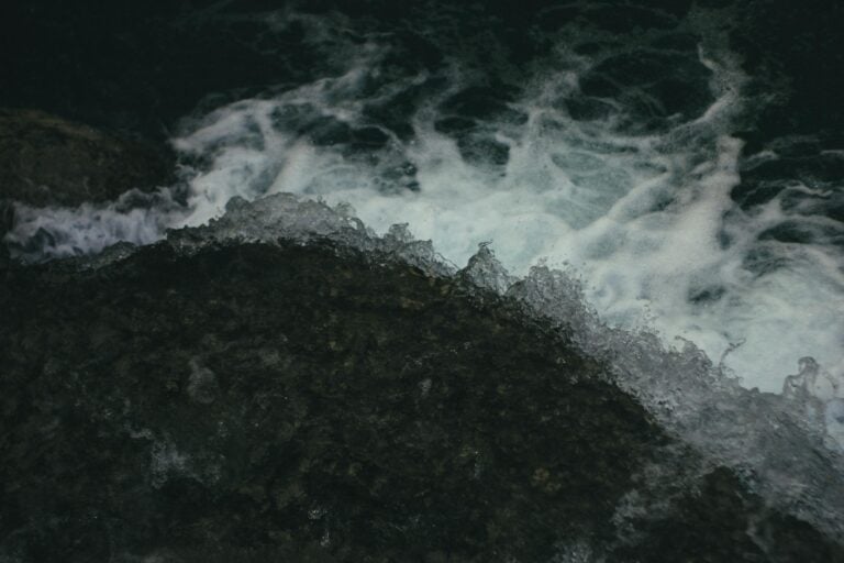 Captivating view of ocean waves crashing against dark rocks showcasing natures raw power