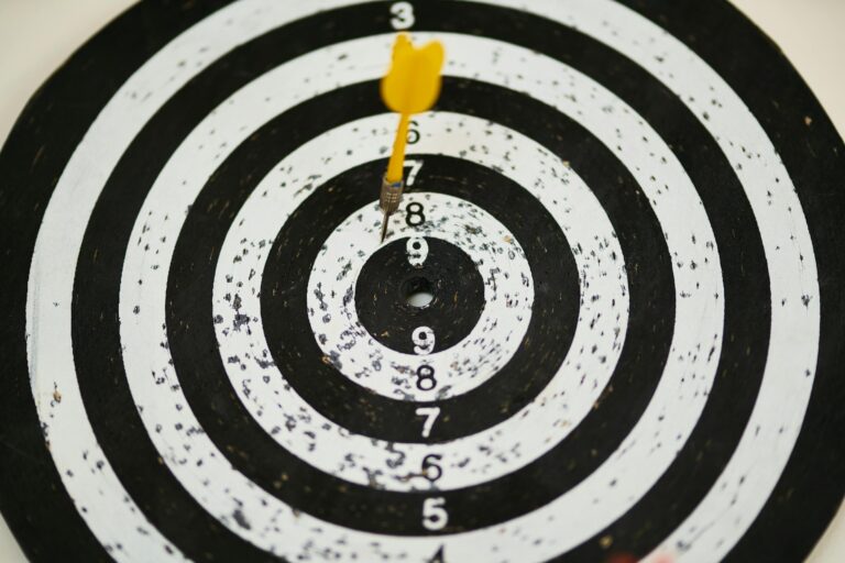 Close-up of dart hitting bullseye on black and white target board symbolizing success