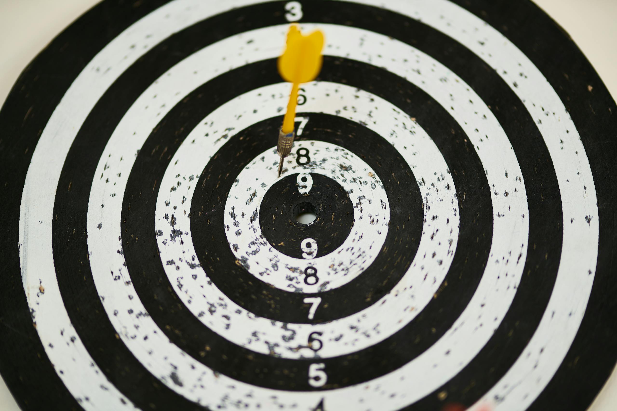 Close-up of dart hitting bullseye on black and white target board symbolizing success