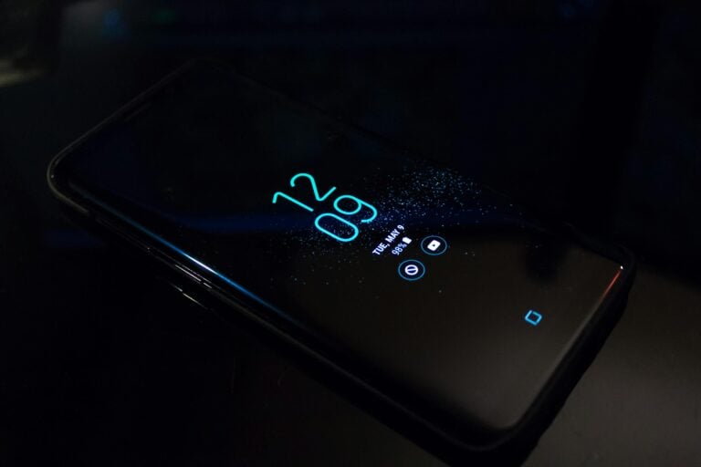 Smartphone in darkness displaying digital clock and notifications.
