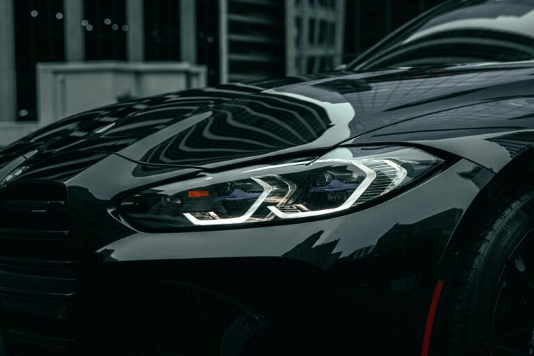 Close-up of black BMW M3 headlight in downtown Chicago showcasing modern design